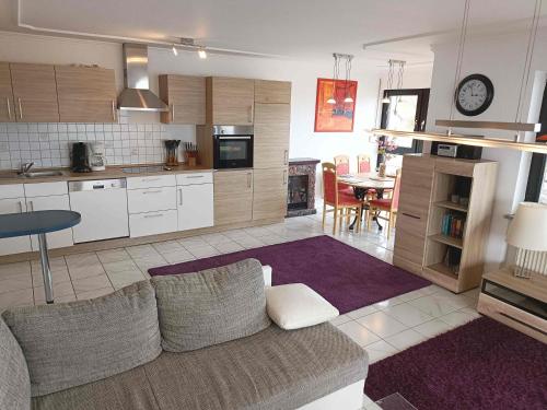 a living room with a couch and a kitchen at Ferienwohnung Seeblick in Schalkenmehren