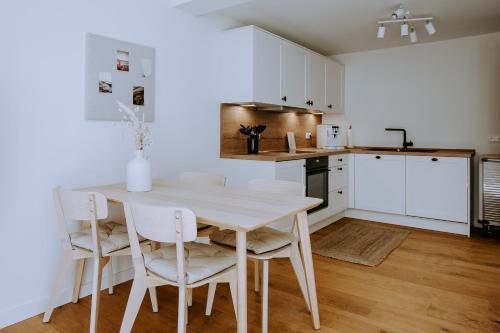 eine weiße Küche mit einem weißen Tisch und Stühlen in der Unterkunft Fritz im Glück in Rietberg