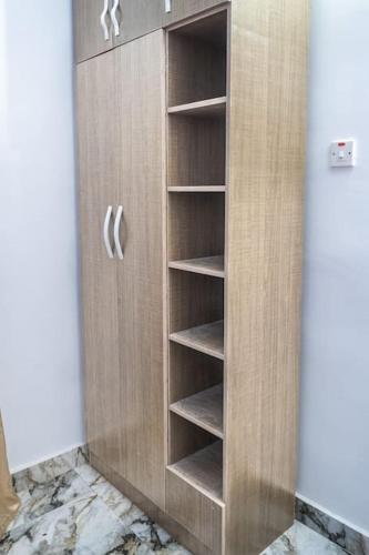 a wooden cabinet with empty shelves in a room at Amazing Waterfront 1-Bed Apt With 24HRS PWR And Starlink SuperFast Speed WiFi in Lagos