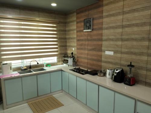 a kitchen with a sink and a counter top at JOE Homestay in Alor Setar