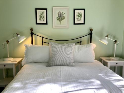 a bedroom with a bed with two lamps on it at Country Bliss Cottage in Greytown