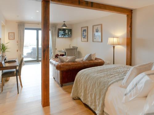 a bedroom with a bed and a desk and a couch at Rum Studio - Ukc6564 in Mallaig