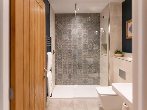 a bathroom with a shower and a toilet and a sink at Rum Studio - Ukc6564 in Mallaig