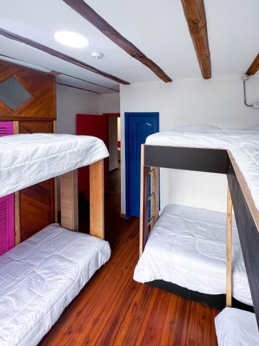 two bunk beds in a room with wooden floors at Ancestral Hostel in Bogotá
