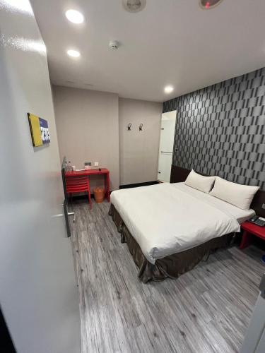 a bedroom with a large bed and a red desk at Sun Star Business Hotel in Taipei