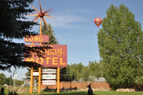 a sign for a motel with a cat flying a kite at Long Holiday Motel in Gunnison