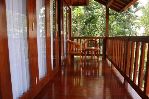 a porch of a house with a chair and windows at Bukit Kembang Sari in Bugbug