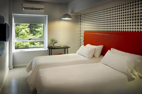 a hotel room with two beds and a window at Velasco House in Buenos Aires