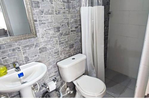 a bathroom with a white toilet and a sink at Apto en Girardot con Balcón, Piscina y Parqueadero in Girardot