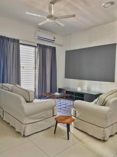 una sala de estar con 2 sofás y una pantalla. en Shah Alam Setia Alam SCCC 3 Storey Semi D 13 Pax, en Shah Alam