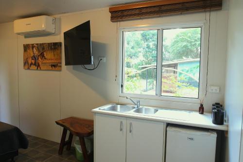 a kitchen with a sink and a window at Banyan Tree in Batchelor