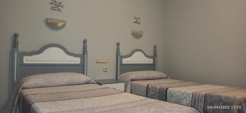 a room with two beds and two mirrors at Hostal San Antonio in Iscar