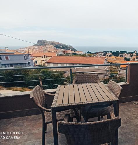 a wooden table and chairs on a balcony with a view at Gioiellino Sardo in Castelsardo