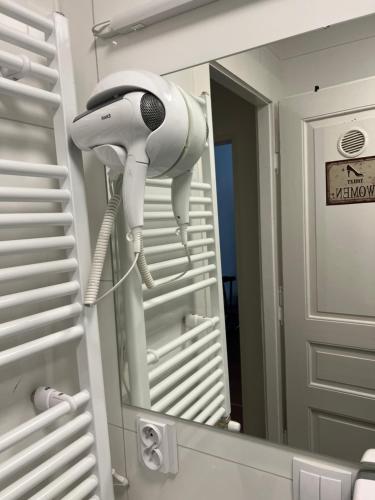 a white hairdryer is reflected in a bathroom mirror at Hostel Jasmin in Prague