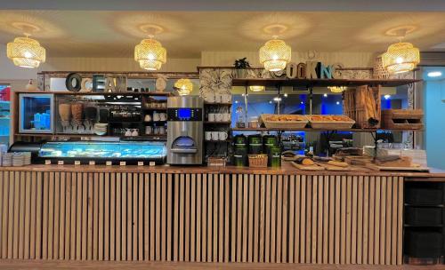 a restaurant with a counter with food on it at ibis Styles St Gilles Croix de Vie centre-ville in Saint-Gilles-Croix-de-Vie