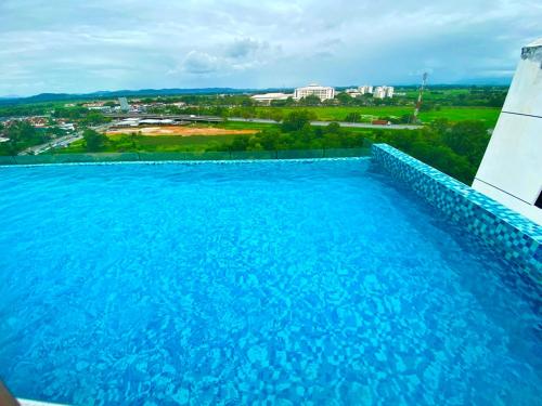 a large blue swimming pool with a view of a city at Imperio Professional Suite by IMPERIO HAFFA in Alor Setar