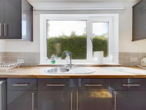 a kitchen with a sink and a window at Zoo Cottage in Chester