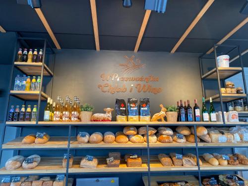 a bakery with a bunch of bread and bottles of wine at 2 Tyskie Apartamenty z ogródkiem in Tychy