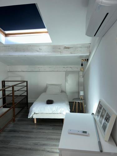 Dormitorio pequeño con cama y mesa en Maison climatisée avec stationnement et wifi, en Bram
