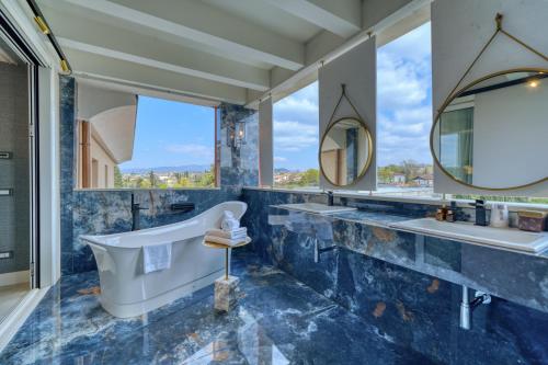 a bathroom with two sinks and a tub and mirrors at Palazzo della Scala Spa Hotel Suites & Apartments in Lazise