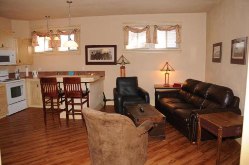 a living room with a couch and a kitchen at Third Mission Heritage Suites in Peace River