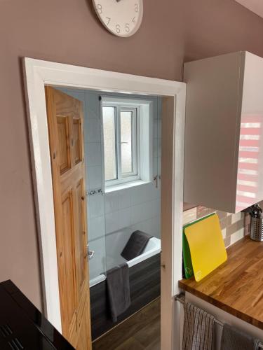 ein Zimmer mit einem Fenster und einer Uhr an der Wand in der Unterkunft Hope Corner in Filey