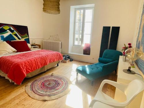 a bedroom with a bed and a blue chair at Maison de charme de 280m2 avec piscine chauffée … in Luçon