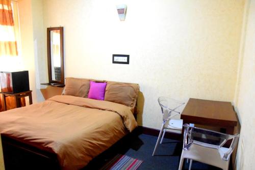 a small bedroom with a bed and a table at Janara Two in Kurunegala