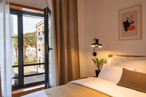 a bedroom with a bed and a view of a balcony at Downtown Vela Luka in Vela Luka