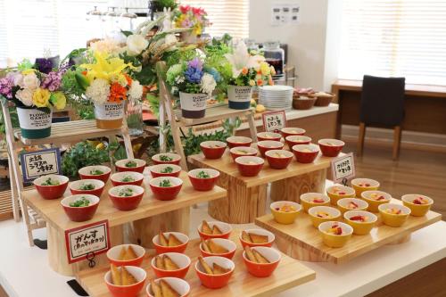 a display of flower arrangements in small bowls on wooden shelves at Hiroshima Tokyu REI Hotel in Hiroshima