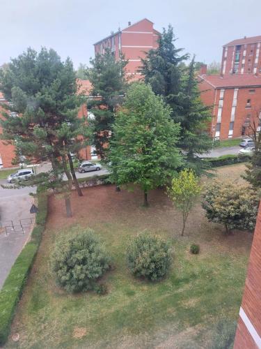 a park with trees and bushes in front of a building at Casa dei GATTI in Turin