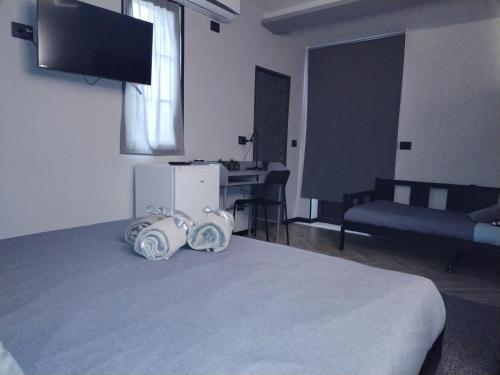 een kamer met een bed, een televisie en een bureau bij B&B Marino in Grisolia