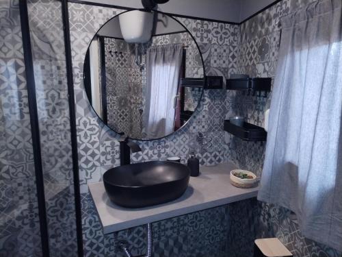 baño con lavabo negro y espejo en B&B Marino, en Grisolia
