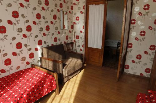 una habitación con una silla y una cama con flores en la pared en Guesthouse Pirosmani, en Borjomi