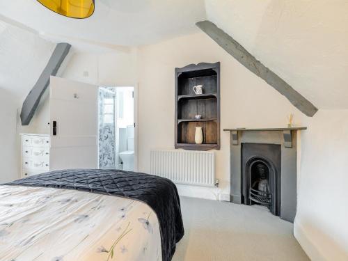 a bedroom with a bed and a fireplace at Weavers Cottage in Torquay