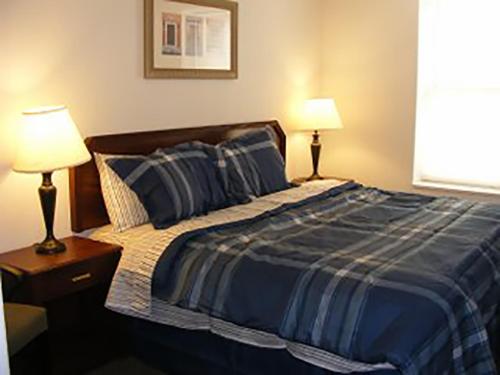 a bedroom with a bed with two lamps on it at Beach Fantasy Apartment Suites in Old Orchard Beach