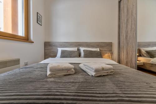 a bedroom with a large bed with two pillows on it at Idila Lux in Zlatibor