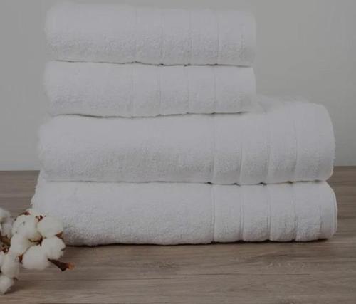 una pila de toallas blancas sentadas en el suelo junto a una toalla en Stbs Luxury, Nea Fokea, en Nea Fokea