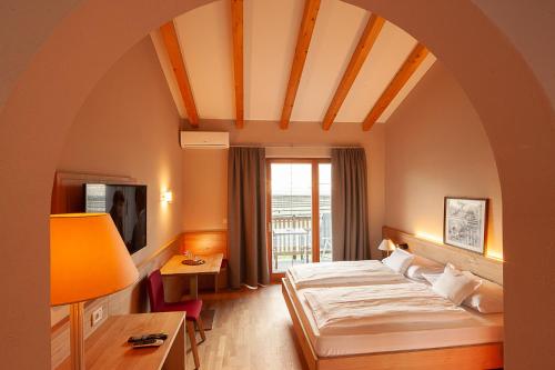 una camera d'albergo con letto e finestra di Ansitz Waldner Oberwirt a Marlengo