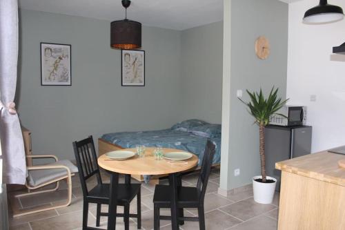 a dining room with a table and chairs and a bed at Studio 30m² à Billey 