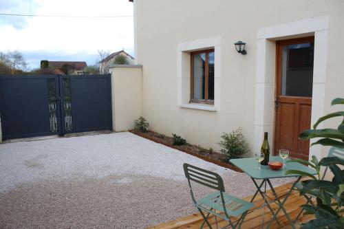 a patio with a blue gate and a table and chairs at Studio 30m² à Billey 