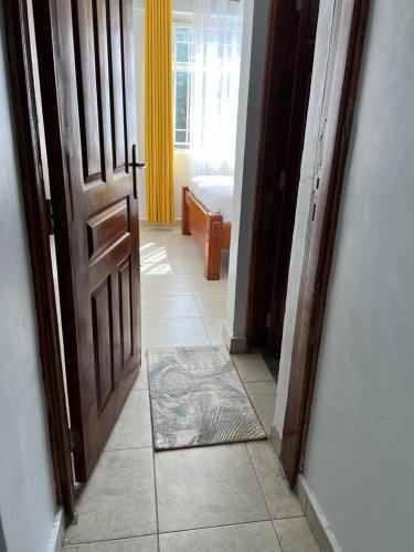 una puerta abierta a una habitación con dormitorio en Comfortplace 2 bedroom, en Kericho