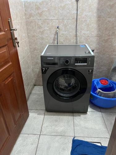 a washing machine sitting in the corner of a bathroom at Comfortplace 2 bedroom in Kericho