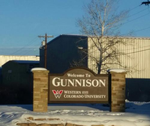 a sign for a gurninson university in the snow at Long Holiday Motel in Gunnison