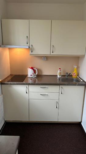 a kitchen with white cabinets and a sink at Apartmán Kovárna in Prášily