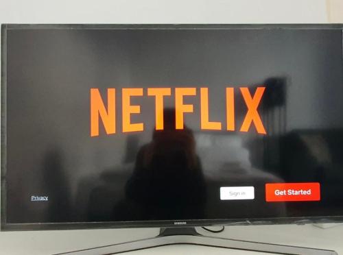 un écran de télévision avec le signe Netflix dessus dans l'établissement Lorena’s Apartment, à Arad
