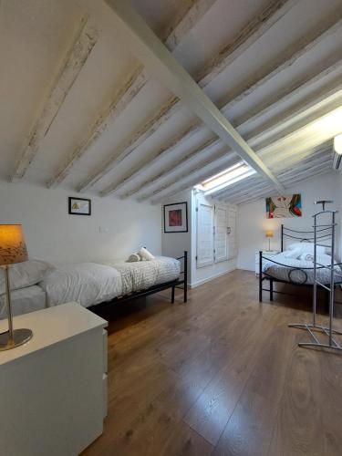 - 2 lits dans une chambre dotée de parquet et de plafonds en bois dans l'établissement Alloggi Palmini, à Florence