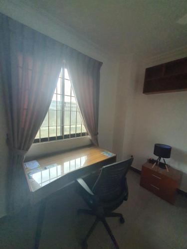 a desk and a chair in a room with a window at MB Apartments & Hotel Medan in Sunggal