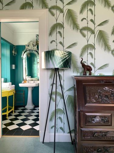 a bathroom with a palm tree mural on the wall at Cairn Bay Lodge in Bangor