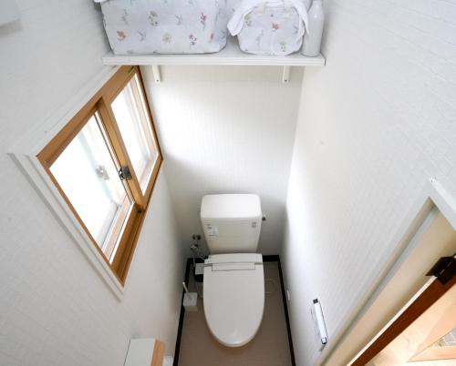 a small bathroom with a toilet and a window at ヒュッテ・ボーデン in Komoro